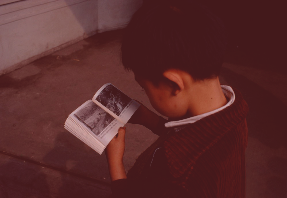 A boy reading a lianhuanhua comic book